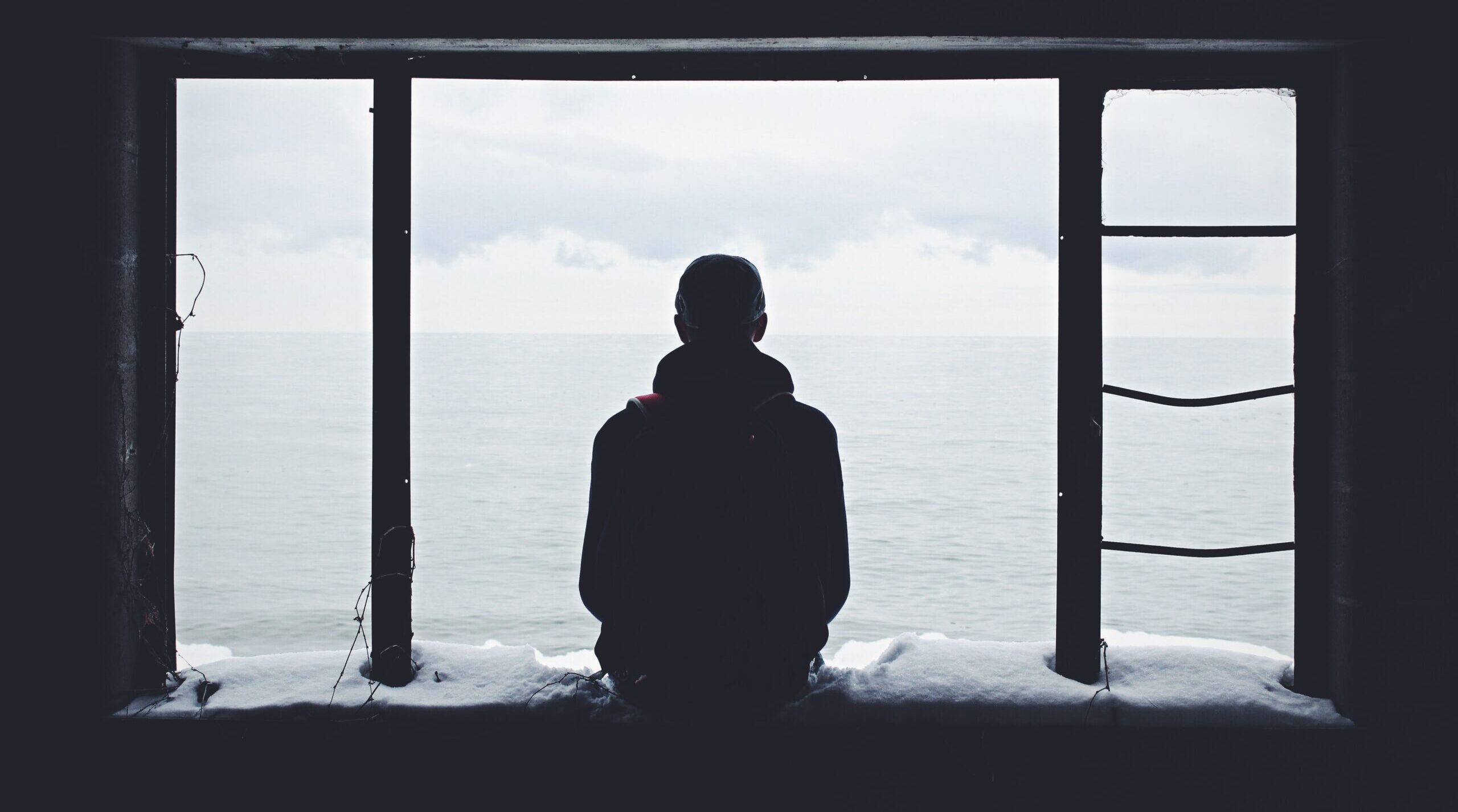 man sitting on window sill