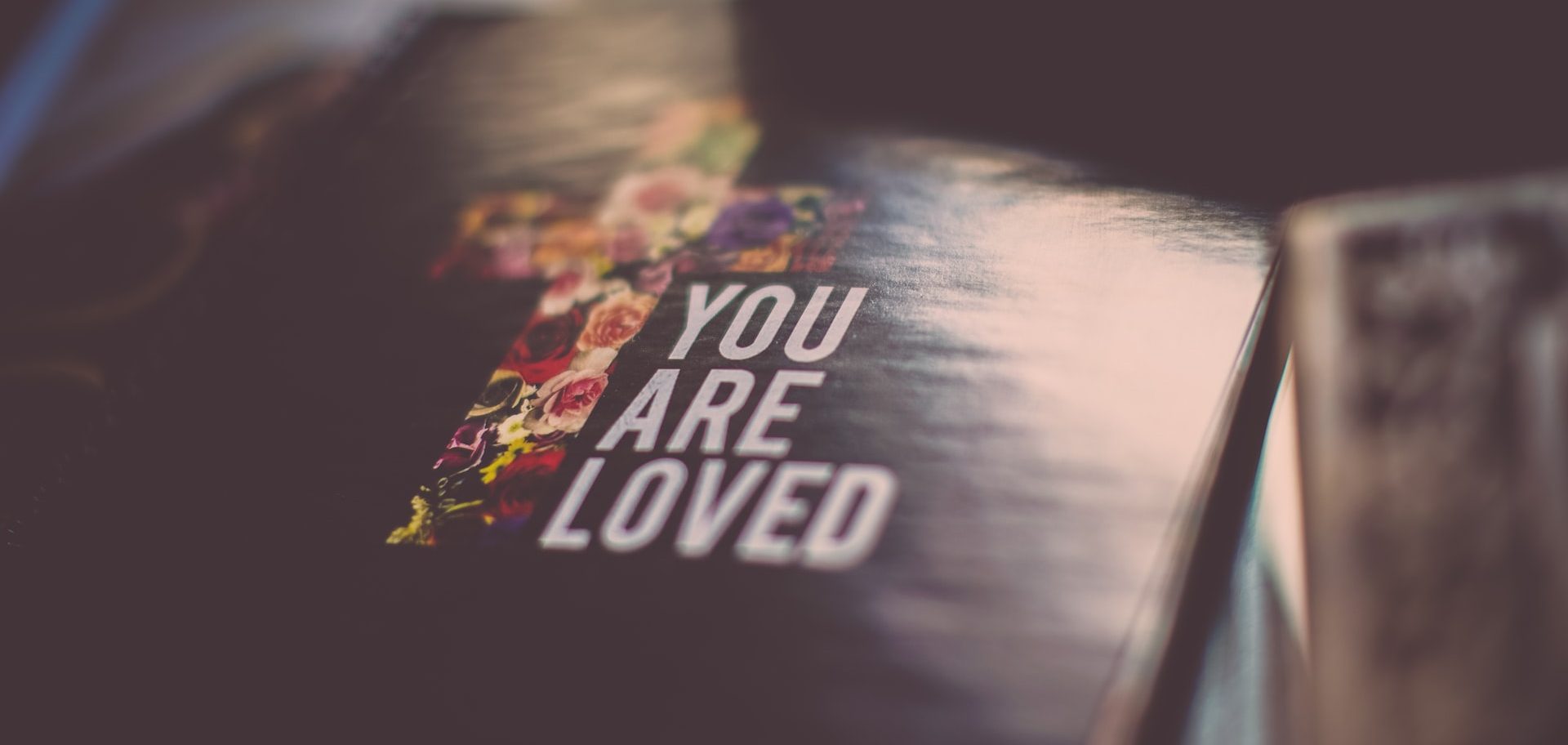 Book with a cross and the words "You are loved" on the cover