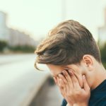 man rubbing face with hands