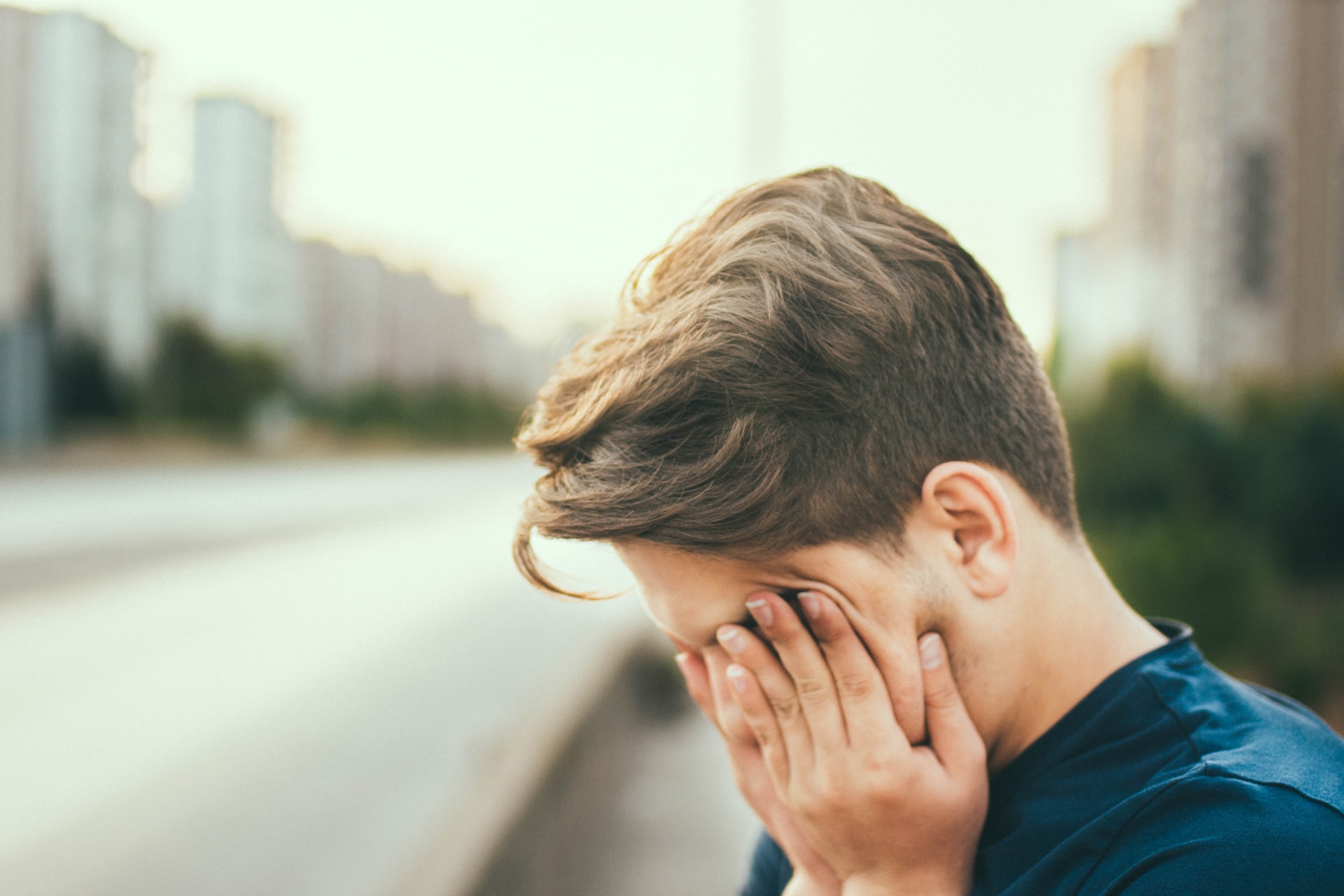 man rubbing face with hands