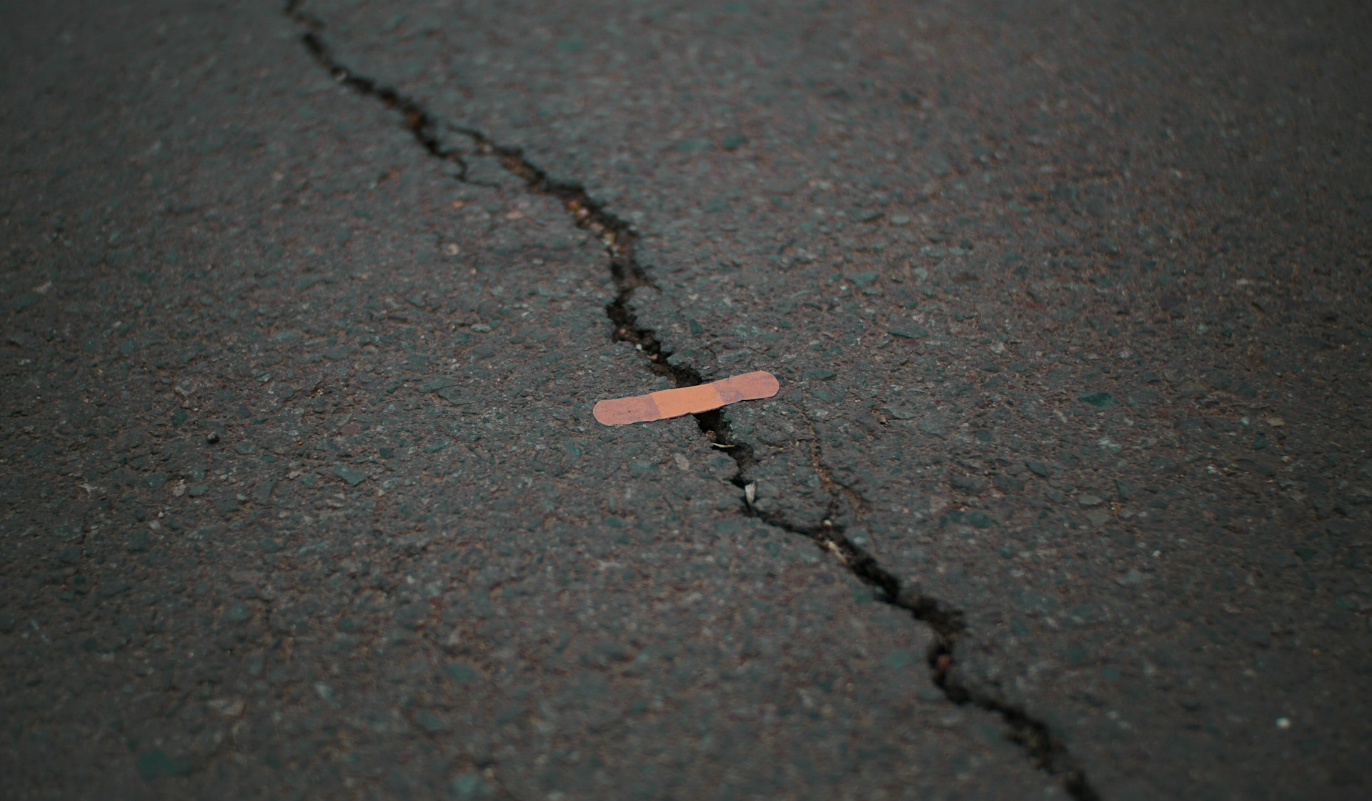band aid on crack in asphalt